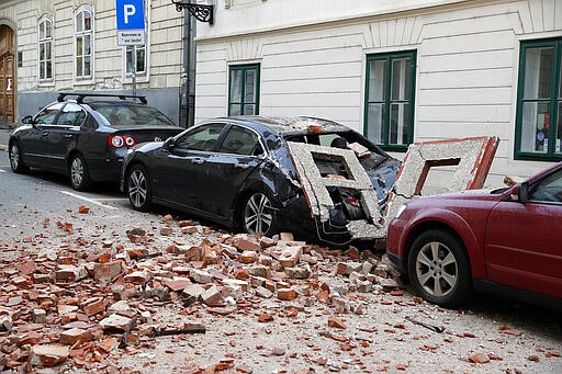 A car is crushed by falling debris after an earthquake in Zagreb, Croatia, Sunday, March 22, 2020. A strong earthquake shook Croatia and its capital on Sunday, causing widespread damage and panic.(AP Photo/Darko Bandic)