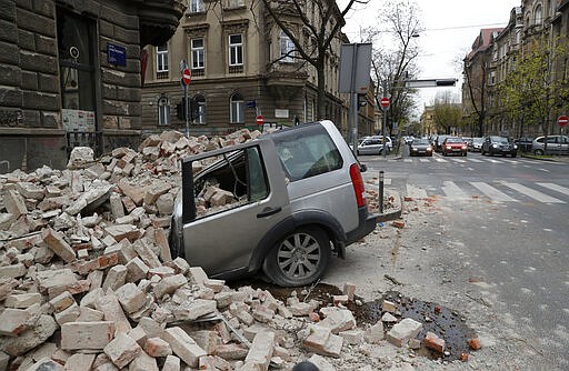 A car is crushed by falling debris after an earthquake in Zagreb, Croatia, Sunday, March 22, 2020. A strong earthquake shook Croatia and its capital on Sunday, causing widespread damage and panic. (AP Photo/Darko Bandic)
