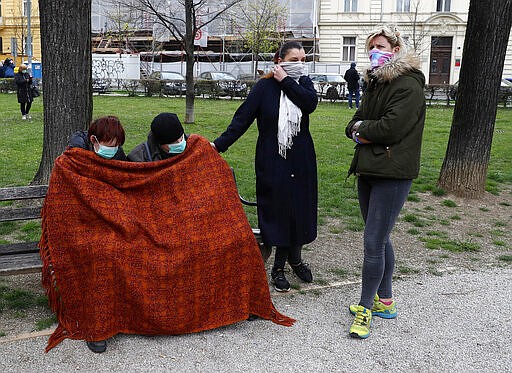 People rest in park after an earthquake in Zagreb, Croatia, Sunday, March 22, 2020. A strong earthquake shook Croatia and its capital on Sunday, causing widespread damage and panic. (AP Photo/Darko Bandic)