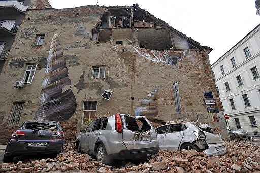 A collapsed wall leaves an exposed home and crushed cars after an earthquake in Zagreb, Croatia, Sunday, March 22, 2020. A strong earthquake shook Croatia and its capital on Sunday, causing widespread damage and panic. (AP Photo)