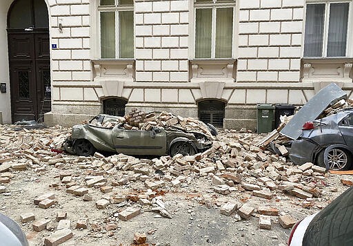 A car is crushed by falling debris after an earthquake in Zagreb, Croatia, Sunday, March 22, 2020. A strong earthquake shook Croatia and its capital on Sunday, causing widespread damage and panic. (AP Photo/Filip Horvat)
