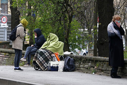 People rest on the street after an earthquake in Zagreb, Croatia, Sunday, March 22, 2020. A strong earthquake shook Croatia and its capital on Sunday, causing widespread damage and panic. (AP Photo/Darko Bandic)