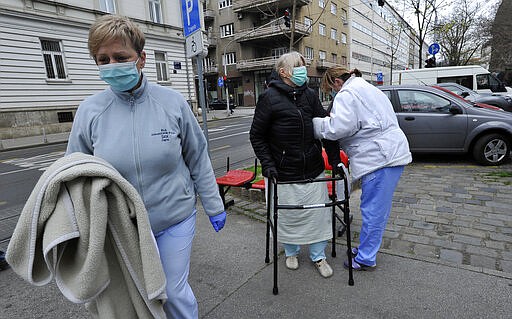 People walk on the street after an earthquake in Zagreb, Croatia, Sunday, March 22, 2020. A strong earthquake shook Croatia and its capital on Sunday, causing widespread damage and panic. (AP Photo)