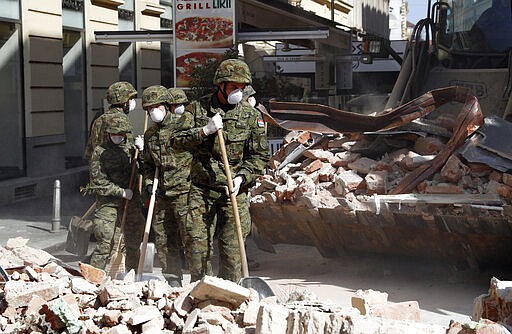 Croatian soldiers clear debris from the street after an earthquake in Zagreb, Croatia, Sunday, March 22, 2020. A strong earthquake shook Croatia and its capital on Sunday, causing widespread damage and panic. (AP Photo/Darko Bandic)