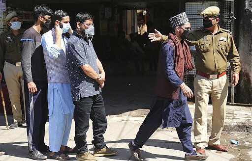 Indian passengers who got stranded at a bus terminal line up for free food being distributed by shop keepers during a day long lockdown amid growing concerns of coronavirus in Jammu, India, Sunday, March 22, 2020. India is observing a 14-hour &#147;people's curfew&#148; called by Prime Minister Narendra Modi in order to stem the rising coronavirus caseload in the country of 1.3 billion. For most people, the new coronavirus causes only mild or moderate symptoms. For some it can cause more severe illness. (AP Photo/Channi Anand)