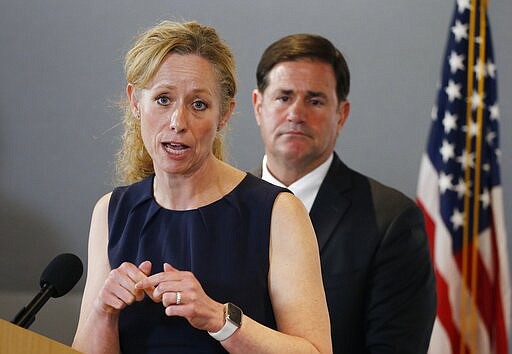 Arizona Department of Health Services Director Dr. Cara Christ, left, answers a question as she is joined by Arizona Gov. Doug Ducey, right, as they provide an update on the coronavirus during a news conference at the Arizona State Public Health Laboratory Monday, March 23, 2020, in Phoenix. (AP Photo/Ross D. Franklin)