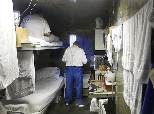 FILE - This Feb. 26, 2013 file photo, shows inmates in a cell at California State Prison, Sacramento, near Folsom, Calif. One inmate and five employees in California&#146;s massive prison system have tested positive for coronavirus, leading to increased pressure Monday, March 23, 2020, on corrections officials to begin releasing some of the state&#146;s 123,000 convicts early. (AP Photo/Rich Pedroncelli, File)