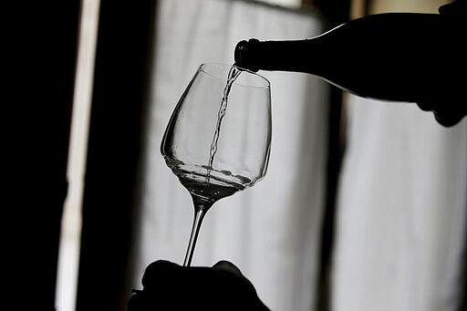 FILE - This Oct. 15, 2018, file photo shows Prosecco wine poured into a glass during a wine tasting at the Case Paolin farm in Volpago del Montello, Italy. Doctors are reporting that people infected with the pandemic virus may lose their sense of smell and perhaps taste. Virus infection is already a known cause of smell loss, and in some cases it can be permanent. But in cases of the pandemic virus, it looks more like a temporary effect. (AP Photo/Luca Bruno, File)