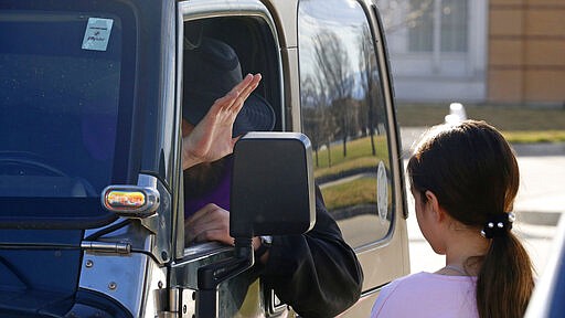 Father Stephen Tilley sits behind his steering wheel as he listens to the confession of Ava Werner, 10, during &quot;Meet Me at the Jeep,&quot; for a drive-up confession at Skaggs Catholic Center, Sunday, March 22, 2020, in Draper, Utah. With the threat of the new coronavirus closing churches, some Catholic priests in Utah offered to hear drive-up confessions. (AP Photo/Rick Bowmer)