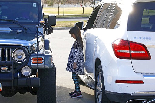 Father Stephen Tilley, left, sits behind his steering wheel as he listens to the confession of Lily Werner, 8, during &quot;Meet Me at the Jeep,&quot; for a drive-up confession at Skaggs Catholic Center, Sunday, March 22, 2020, in Draper, Utah. With the threat of the new coronavirus closing churches, some Catholic priests in Utah offered to hear drive-up confessions. (AP Photo/Rick Bowmer)