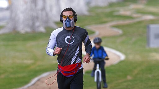 Tom Watson runs in Liberty Park while wearing a mask Monday, March 23, 2020, Salt Lake City. (AP Photo/Rick Bowmer)