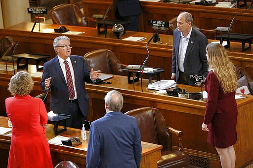 Nebraska Speaker of the Legislature Jim Scheer of Norfolk, top left, addresses fellow senators at the State Capitol in Lincoln, Neb., Monday, March 23, 2020. Nebraska lawmakers reconvened on Monday to pass emergency funding for the coronavirus outbreak. (AP Photo/Nati Harnik)