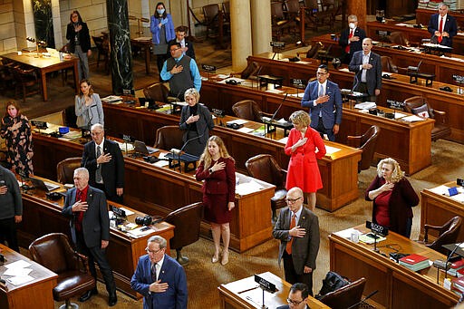 Nebraska state senators recite the Pledge of Allegiance at the State Capitol in Lincoln, Neb., Monday, March 23, 2020. Nebraska lawmakers reconvened on Monday to pass emergency funding for the coronavirus outbreak. (AP Photo/Nati Harnik)