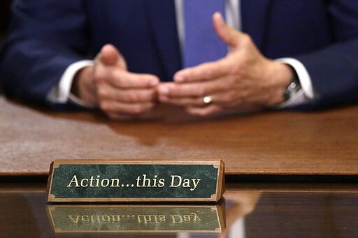 A plaque sits on the desk as Washington Gov. Jay Inslee prepares to speak about additional plans to slow the spread of coronavirus before a televised address from his office Monday, March 23, 2020, in Olympia, Wash. The latest update from the Washington state Department of Health showed there have been at least 110 coronavirus deaths in the state and more than 2,200 confirmed cases. (AP Photo/Elaine Thompson)