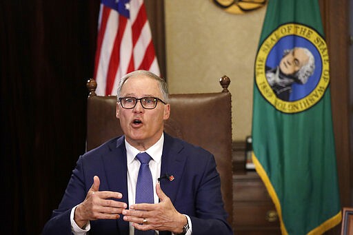 Washington Gov. Jay Inslee practices as he prepares to speak about additional plans to slow the spread of coronavirus before a televised address from his office Monday, March 23, 2020, in Olympia, Wash. Inslee has ordered non-essential businesses to close and the state's more than 7 million residents to stay home unless necessary in order to slow the spread of COVID-19. (AP Photo/Elaine Thompson)