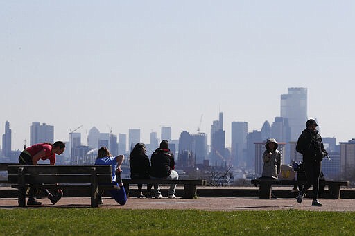 Pedestrians walk on Primrose Hill with the skyline of central London as a backdrop in London, Monday, March 23, 2020. The British government is encouraging people to practice social distancing to help prohibit the spread of Coronavirus, further restrictions may be imposed if the public do not adhere to their advice. For most people, the new coronavirus causes only mild or moderate symptoms, such as fever and cough. For some, especially older adults and people with existing health problems, it can cause more severe illness, including pneumonia. (AP Photo/Frank Augstein)