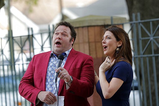 Opera singers Irini Hymel, right, and Bryan Hymel sing to quarantined residents of Lambeth House, where a cluster of the coronavirus has formed, in New Orleans, Friday, March 20, 2020. (AP Photo/Gerald Herbert)