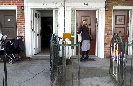 In this March 19, 2020 photo, Freida Rothman drops off a meal for a Holocaust survivor in Brooklyn, New York. Volunteers like Rothman are helping ensure Holocaust survivors isolated in their homes because of coronavirus concerns have access to food. (AP Photo/Jessie Wardarski)