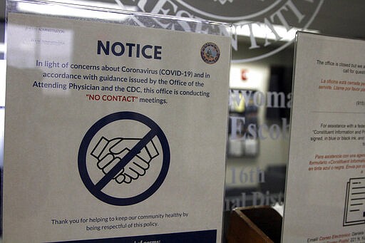 A notice on the door of Rep. Veronica Escobar, D-Texas, explains that it is closed to in-person visits on Wednesday, March 18, 2020, in El Paso, Texas. Inside, Escobar answered questions from constituents during in a virtual town hall about the coronavirus. (AP Photo/Cedar Attanasio)