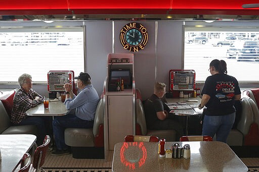 A waitress takes an order at Dixie's Diner in Idaho Falls, Idaho on Monday, March 23, 2020. Dixie's Diner staff are seating people with a booth spacing between diners to help prevent the spread of the novel coronavirus while still keeping their doors open. (John Roark/The Idaho Post-Register via AP)