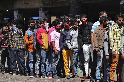 Indian passengers who got stranded at a bus terminal line up for free food being distributed by shop keepers during a day long lockdown amid growing concerns of coronavirus in Jammu, India, Sunday, March 22, 2020. India is observing a 14-hour &#147;people's curfew&#148; called by Prime Minister Narendra Modi in order to stem the rising coronavirus caseload in the country of 1.3 billion. India's government has made fervent appeals to the public to practice social distancing, but experts say, the same is nearly impossible in many Indian cities that are among the world's most densely populated areas. For most people, the new coronavirus causes only mild or moderate symptoms. For some it can cause more severe illness. (AP Photo/Channi Anand)