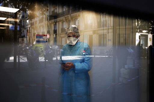 Biologist doctor Caroline Gutsmuth gives a phone call in medical biology laboratory who opened a coronavirus drive-thru testing site, in Neuilly-sur-Seine, near Paris, Monday, March 23, 2020. French President Emmanuel Macron urged employees to keep working in supermarkets, production sites and other businesses that need to keep running amid stringent restrictions of movement due to the rapid spreading of the new coronavirus in the country. For most people, the new coronavirus causes only mild or moderate symptoms. For some it can cause more severe illness, especially in older adults and people with existing health problems. (AP Photo/Christophe Ena)