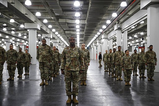 The National Guard stands in formation at the Jacob Javits Center, Monday, March 23, 2020, in New York. New York City hospitals are just 10 days from running out of &quot;really basic supplies,&quot; Mayor Bill de Blasio said late Sunday. De Blasio has called upon the federal government to boost the city's quickly dwindling supply of protective equipment. The city also faces a dearth of ventilators to treat those infected by the coronavirus. (AP Photo/John Minchillo)