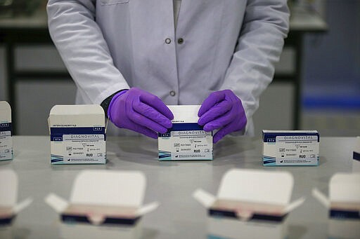 Wearing protective equipment a research and development company worker works on the production of coronavirus testing kits in Gebze, northwestern Turkey, Monday, March 23, 2020. RTA laboratories are now producing 500,000 kits per week for export and their tests are being used in 11 countries across Europe, Middle East and Asia. The test takes up to three hours to return results that have &quot;a sensitivity precision of 99.5%,&quot; according to the lab's director. For most people, the new coronavirus causes only mild or moderate symptoms, such as fever or coughing. But for some older adults and people with existing health problems, it can cause more severe illness, including pneumonia. (AP Photo/Emrah Gurel)