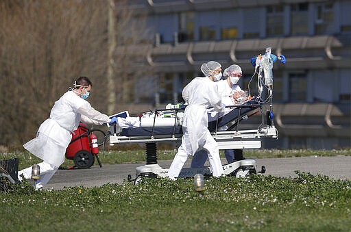 A victim of the Covid-19 virus is evacuated from the Mulhouse civil hospital, eastern France, Monday March 23, 2020. The Grand Est region is now the epicenter of the outbreak in France, which has buried the third most virus victims in Europe, after Italy and Spain. For most people, the new coronavirus causes only mild or moderate symptoms. For some it can cause more severe illness. (AP Photo/Jean-Francois Badias)