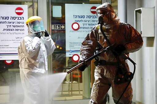 ?A firefighter sprays disinfectant as a precaution? against the coronavirus at the Moshe Dayan Railway Station in Rishon LeTsiyon, Israel, Sunday, March 22, 2020. (AP Photo/Ariel Schalit)