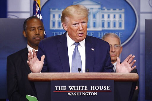 President Donald Trump speaks during a coronavirus task force briefing at the White House, Saturday, March 21, 2020, in Washington.Housing and Urban Development Secretary Ben Carson, left, and Director of the National Institute of Allergy and Infectious Diseases Dr. Anthony Fauci listen. (AP Photo/Patrick Semansky)