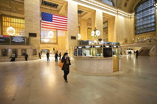 Commuters pass through Grand Central Terminal during the morning rush hour, Monday, March 23, 2020, in New York. Gov. Andrew Cuomo has ordered most New Yorkers to stay home from work to slow the coronavirus pandemic. (AP Photo/Mark Lennihan)