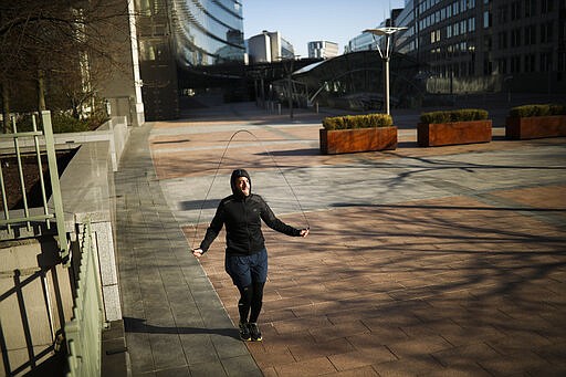 A man jumps rope as he works out in a nearly empty square outside the European Parliament during a partial lockdown ordered by Belgium government in Brussels, Monday, March 23, 2020. For some people the COVID-19 coronavirus causes mild or moderate symptoms, but for some it causes severe illness. (AP Photo/Francisco Seco)