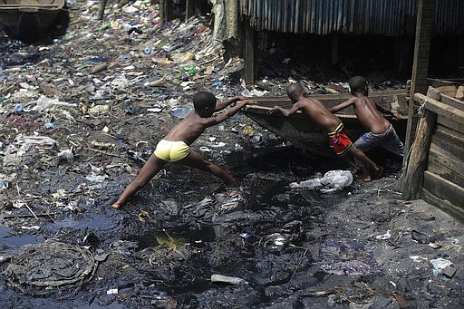 Children pull out a canoe in the floating slum of Makoko in Lagos, Nigeria, Saturday March 21, 2020. Lockdowns have begun in Africa as coronavirus cases rise above 1,000, while Nigeria on Saturday announced it is closing airports to all incoming international flights for one month in the continent's most populous country. Concerns are mounting for the welfare of Nigeria's most vulnerable community on stilts over spread of Covid-19 with little or no chances for social distancing as confirmed positive cases of the disease is on the rise. (AP Photo/Sunday Alamba)