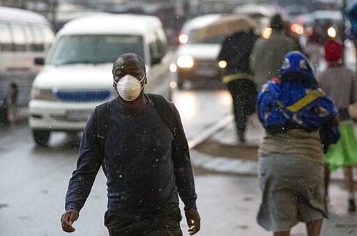 A man wearing a mask, walks on the street in Tembisa, east of Johannesburg, South Africa, Monday, March 23, 2020. South Africa, Africa's most industralized economy and a nation of 57 million people, will to go into a nationwide lockdown for 21 days from Thursday to fight the spread of the new coronavirus. (AP Photo/Themba Hadebe)