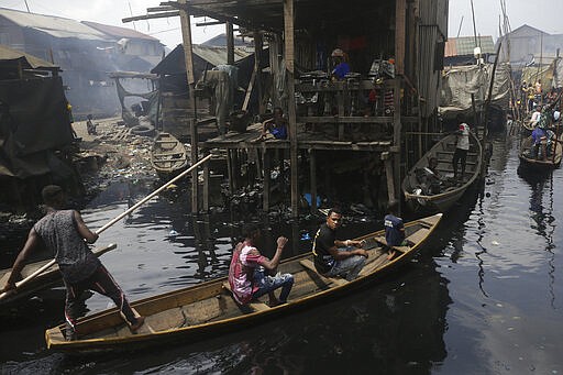 People travel by canoe in the floating slum of Makoko in Lagos, Nigeria, Saturday March 21, 2020. Lockdowns have begun in Africa as coronavirus cases rise above 1,000, while Nigeria on Saturday announced it is closing airports to all incoming international flights for one month in the continent's most populous country. Concerns are mounting for the welfare of Nigeria's most vulnerable community on stilts over spread of Covid-19 with little or no chances for social distancing as confirmed positive cases of the disease is on the rise. (AP Photo/Sunday Alamba)