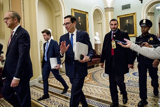 Treasury Secretary Steven Mnuchin, third from left, and White House Legislative Affairs Director Eric Ueland, left, walk to a meeting with Senate Minority Leader Sen. Chuck Schumer of N.Y. in his office on Capitol Hill, Monday, March 23, 2020, in Washington. The Senate is working to pass a coronavirus relief bill. (AP Photo/Andrew Harnik)