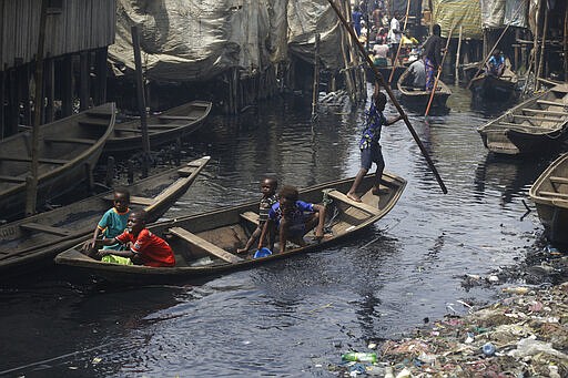 People travel by canoe in the floating slum of Makoko in Lagos, Nigeria, Saturday March 21, 2020. Lockdowns have begun in Africa as coronavirus cases rise above 1,000, while Nigeria on Saturday announced it is closing airports to all incoming international flights for one month in the continent's most populous country. Concerns are mounting for the welfare of Nigeria's most vulnerable community on stilts over spread of Covid-19 with little or no chances for social distancing as confirmed positive cases of the disease is on the rise. (AP Photo/Sunday Alamba)