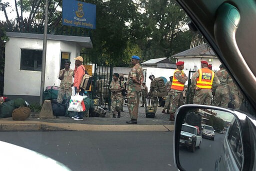 South African troops arrive at the Rand Light Infantry barracks in Johannesburg, South Africa, Monday, March 23, 2020. South African President Cyril Ramaphosa is to address the nation later in the day to announce the latest measures taken to mitigate the spread to the coronavirus in South Africa. For most people the virus causes only mild or moderate symptoms. For others it can cause more severe illness, especially in older adults and people with existing health problems. (AP Photo/Jerome Delay)