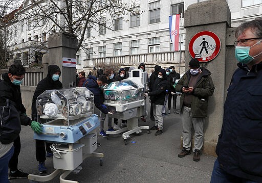 People carry incubators for newborn babies as the hospital is evacuated after an earthquake in Zagreb, Croatia, Sunday, March 22, 2020. A strong earthquake shook Croatia and its capital on Sunday, causing widespread damage and panic. (AP Photo/Darko Bandic)