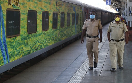 Police officers wearing masks walk on a deserted platform of Lokmanya Tilak Terminus in Mumbai, India, Monday, March 23, 2020. As India expanded its virus-containment measures and halted its lifeblood train network, the federal government warned Monday of strict legal action for those who flout the rules. For most people, the new coronavirus causes only mild or moderate symptoms. For some it can cause more severe illness. (AP Photo/Rafiq Maqbool)