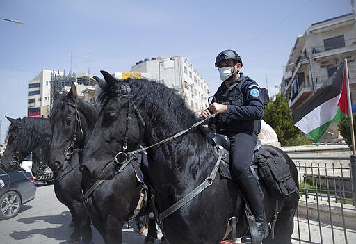 Horse mounted Palestinian policemen deploy to enforce new government measures against the coronavirus, in the West Bank city of Ramallah, Monday, March 23, 2020. On Sunday Palestinian Prime Minister Mohammad Shtayyeh declared a two week set of strict precautionary measures that include confining residents to their homes, restricting movement between cities and deploying security forces, along with other measures to contain the COVID-19 outbreak. (AP Photo/Nasser Nasser)