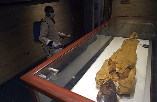 A worker disinfects in the hall of the Queens, in an effort to help prevent the spread of the coronavirus, at the Egyptian Museum in Tahrir Square, Cairo, Egypt, Monday, March 23, 2020. (AP Photo/Hamada Elrasam)