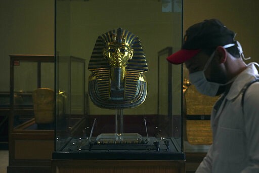 A worker disinfects around King Tut's famous mask in the Egyptian Museum in an effort to help prevent the spread of the coronavirus, in Tahrir Square, Cairo, Egypt, Monday, March 23, 2020. (AP Photo/Hamada Elrasam)