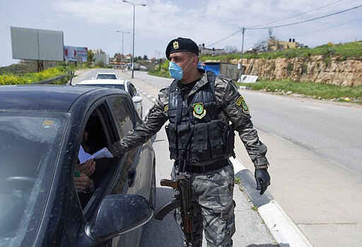 Palestinian security forces are deployed to enforce new government measures against the coronavirus, in the West Bank city of Ramallah, Monday, March 23, 2020. On Sunday, Palestinian Prime Minister Mohammad Shtayyeh declared a two week set of strict precautionary measures that include confining residents to their homes, restricting movement between cities and deploying security forces, along with other measures to contain the COVID-19 outbreak. (AP Photo/Nasser Nasser)