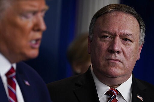 Secretary of State Mike Pompeo, right, listens as President Donald Trump speaks during a coronavirus task force briefing at the White House, Friday, March 20, 2020, in Washington. (AP Photo/Evan Vucci)