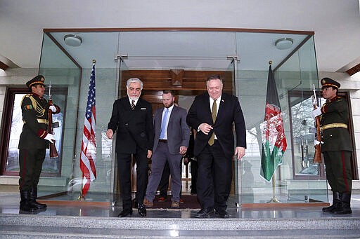 U.S. Secretary of State Mike Pompeo, center right, and Abdullah Abdullah the main political rival of President Ashraf Ghani, center left, walk at the Sepidar palace, in Kabul, Afghanistan, Monday, March 23, 2020. Pompeo was in Kabul on an urgent visit Monday to try to move forward a U.S. peace deal signed last month with the Taliban, a trip that comes despite the coronavirus pandemic, at a time when world leaders and statesmen are curtailing official travel. (Sepidar palace via AP)