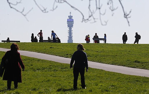 Pedestrians walk on Primrose Hill with the Post Office Tower as a backdrop in London, Monday, March 23, 2020. The British government is encouraging people to practice social distancing to help prohibit the spread of Coronavirus, further restrictions may be imposed if the public do not adhere to their advice. For most people, the new coronavirus causes only mild or moderate symptoms, such as fever and cough. For some, especially older adults and people with existing health problems, it can cause more severe illness, including pneumonia. (AP Photo/Frank Augstein)