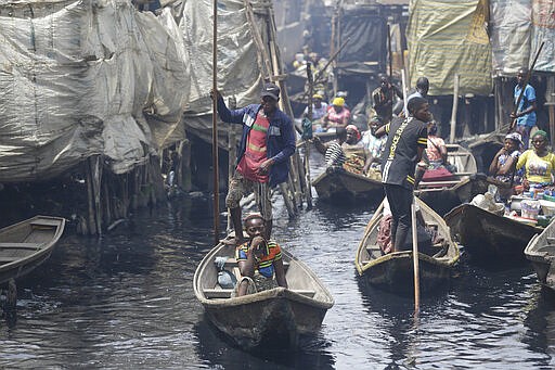 People travel by canoe in the floating slum of Makoko in Lagos, Nigeria, Saturday March 21, 2020. Lockdowns have begun in Africa as coronavirus cases rise above 1,000, while Nigeria on Saturday announced it is closing airports to all incoming international flights for one month in the continent's most populous country. Concerns are mounting for the welfare of Nigeria's most vulnerable community on stilts over spread of Covid-19 with little or no chances for social distancing as confirmed positive cases of the disease is on the rise. (AP Photo/Sunday Alamba)