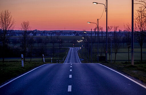 An empty road is seen in the outskirts of Frankfurt, Germany, just before sunrise on Monday, March 23, 2020, the day after the German government spoke out more restrictions to avoid the spread of the. Coronavirus. For most people, the new coronavirus causes only mild or moderate symptoms, such as fever and cough. For some, especially older adults and people with existing health problems, it can cause more severe illness, including pneumonia. (AP Photo/Michael Probst)